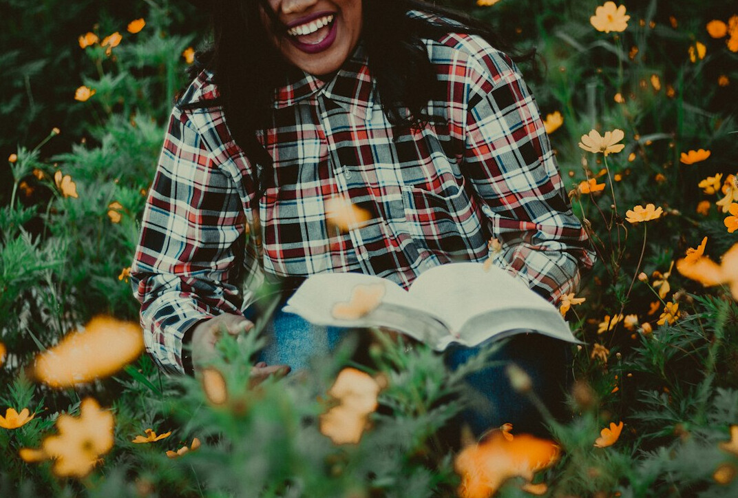 Smiling young woman with brown hair in a cozy reading corner