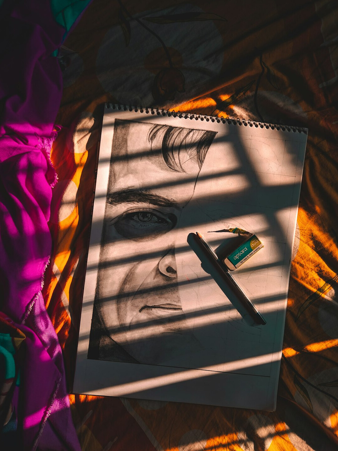 Pen writing on paper next to a notebook